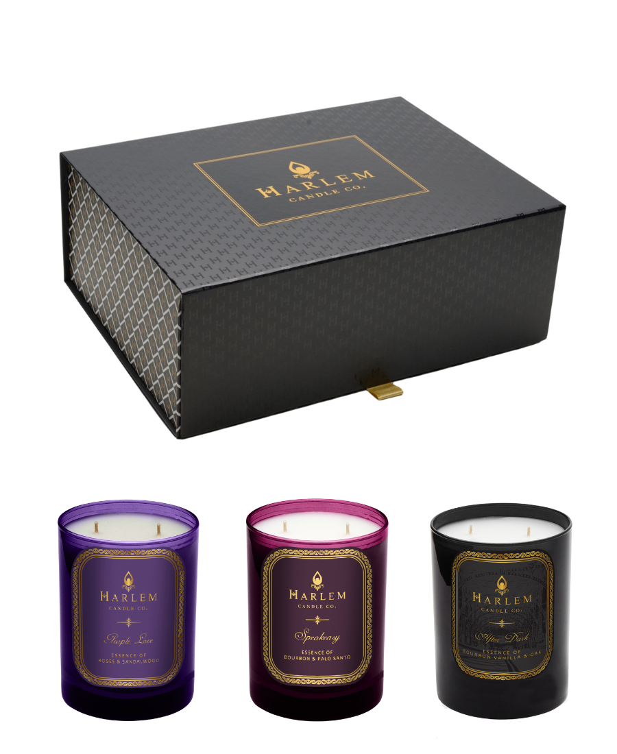 This is an image of our luxurious gift box with our purple love, speakeasy, and after dark candles positioned in front.