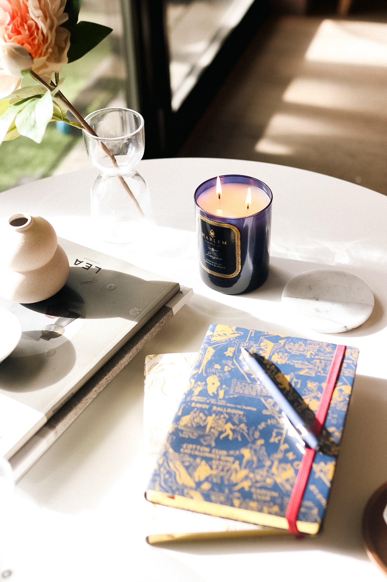 This is an image of our nightclub map of Harlem, navy and gold journal pictured next to our Langston candle