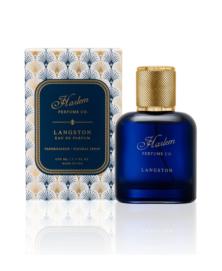 A beautiful blue perfume bottle called Langston with a textured gold cap with a white background. Next to the bottle is a blue and gold box that the perfume comes in.