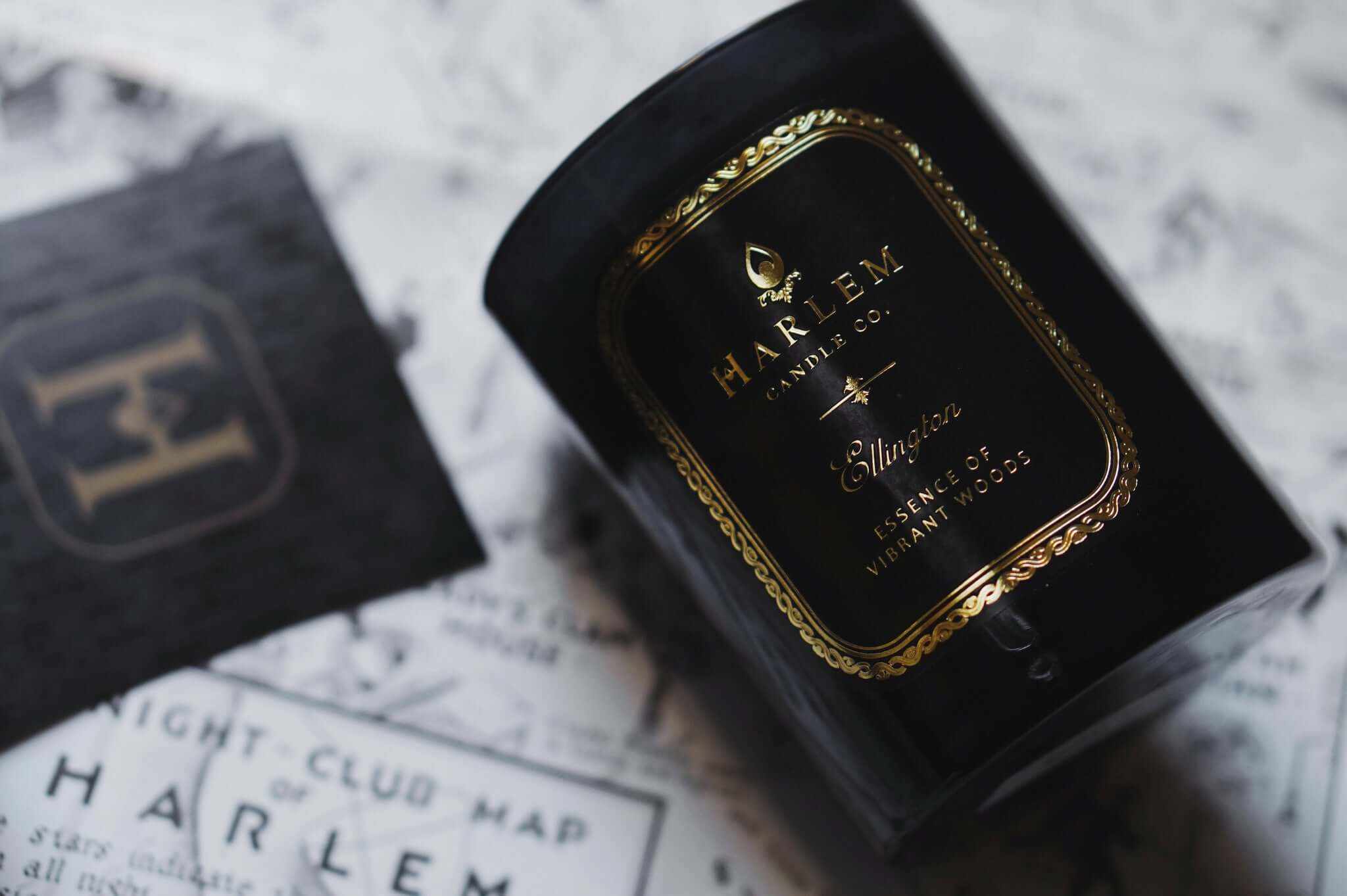 This is an image of our Ellington candle with a nightclub map of Harlem illustration in the background.