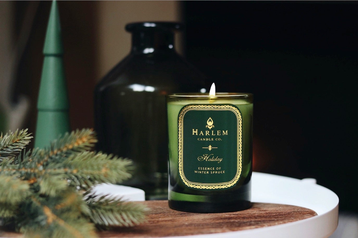 Hunter green glass 12 oz Holiday candle with one wick with a festive background