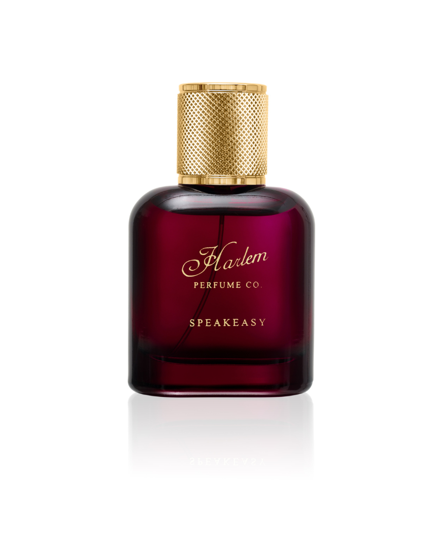An image of our 50 ml / 1.7 oz Speakeasy eau de parfum in a rich burgundy bottle with a gold cap and the  Harlem Perfume Co logo on the bottle with the word Speakeasy in all caps in a block print font.