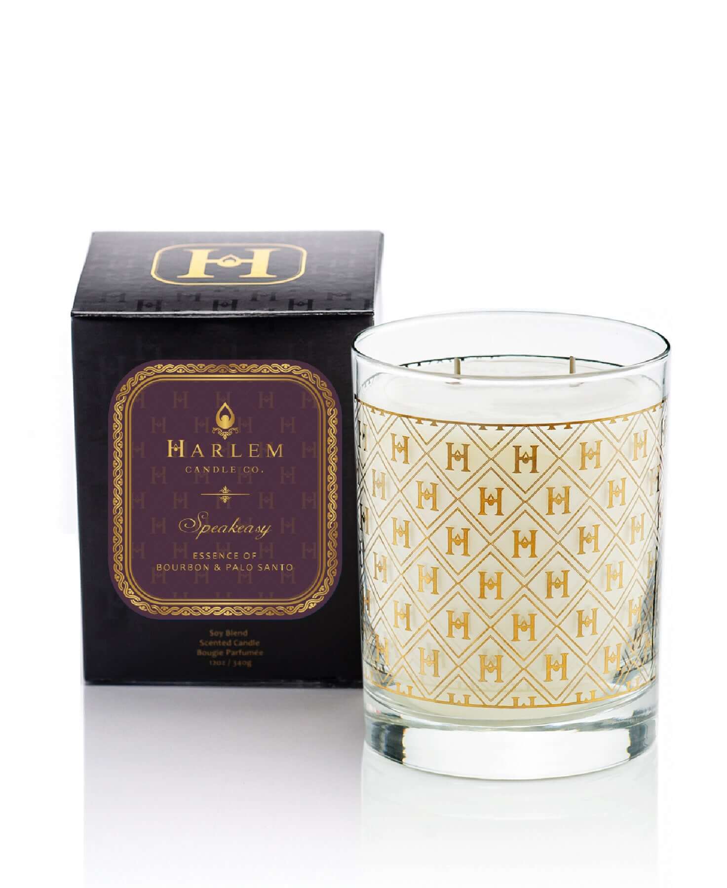 Our stunning 12 oz 22k Cocktail Glass Luxury Speakeasy Candle with the 22K Gold H pattern on clear glass sitting next to its decorative box on a white background.
