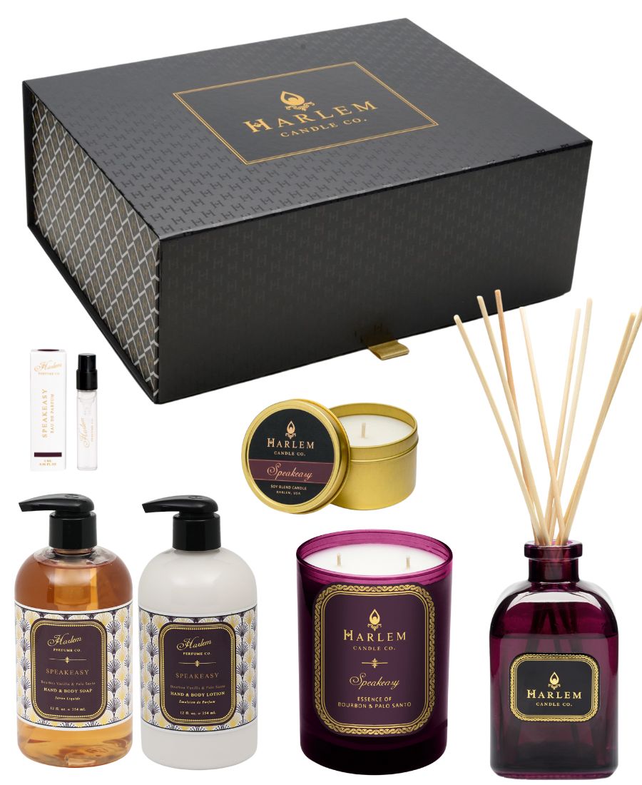 This is a product image of the Speakeasy vibes collection, which includes our elegant Harlem Candle Company gift box, our Speakeasy soap and lotion set, our Speakeasy 11 ounce candle, our Speakeasy reed diffuser, our Speakeasy travel candle, and a 2 ounce sample of our Speakeasy Perfume.
