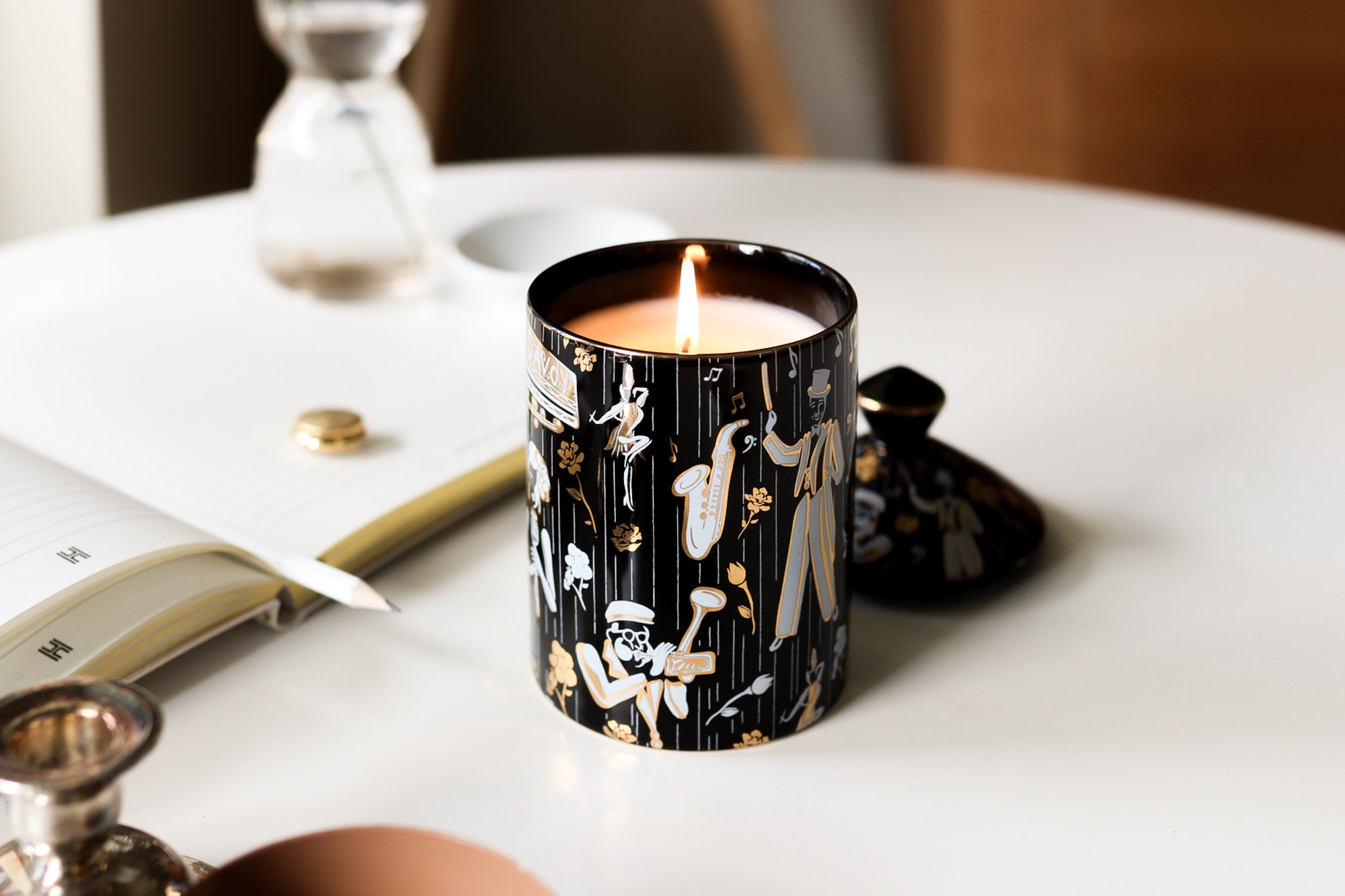 This is a lifestyle image of our Duke ceramic candle picture next to the Harlem design company journal