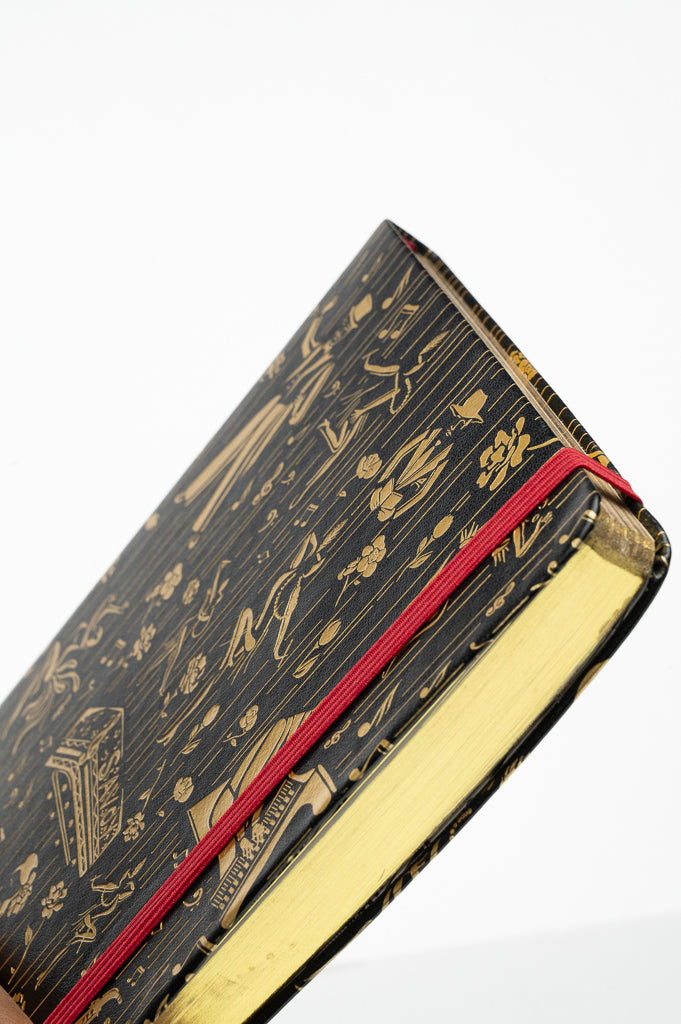 This is a image of the Harlem Renaissance inspired journal, showing the gold page edges and crimson elastic band.