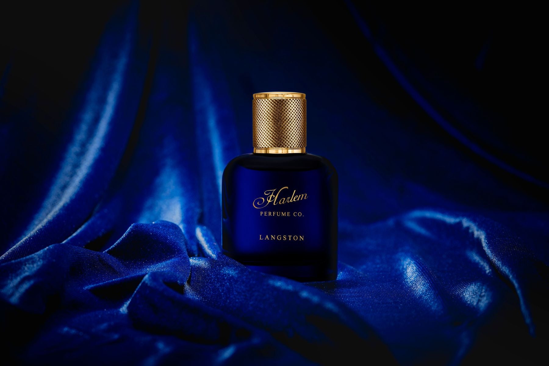 This is an image of our Langston eau de parfum 1.7 oz bottle sitting on a blue velvet fabric.