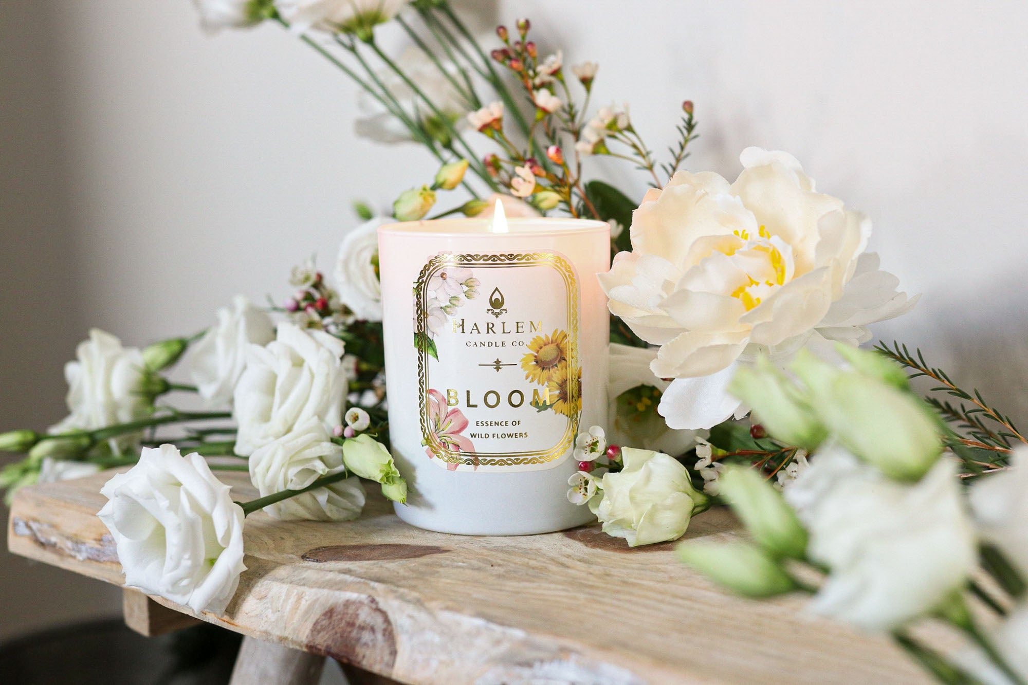 This is a lifestyle image of our bloom candle, surrounded by flowers