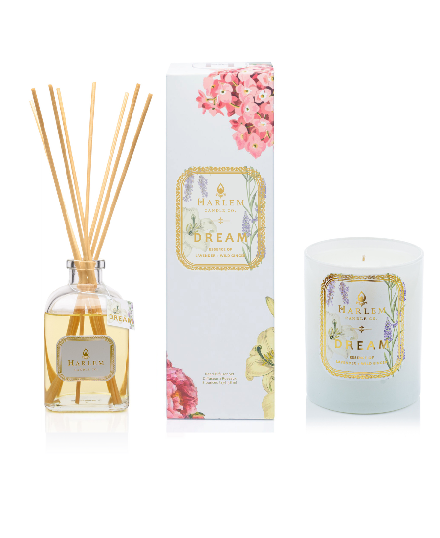 This is an image of our dream diffuser bottle in a clear glass next to its decorative box, and the dream candle with one wick.