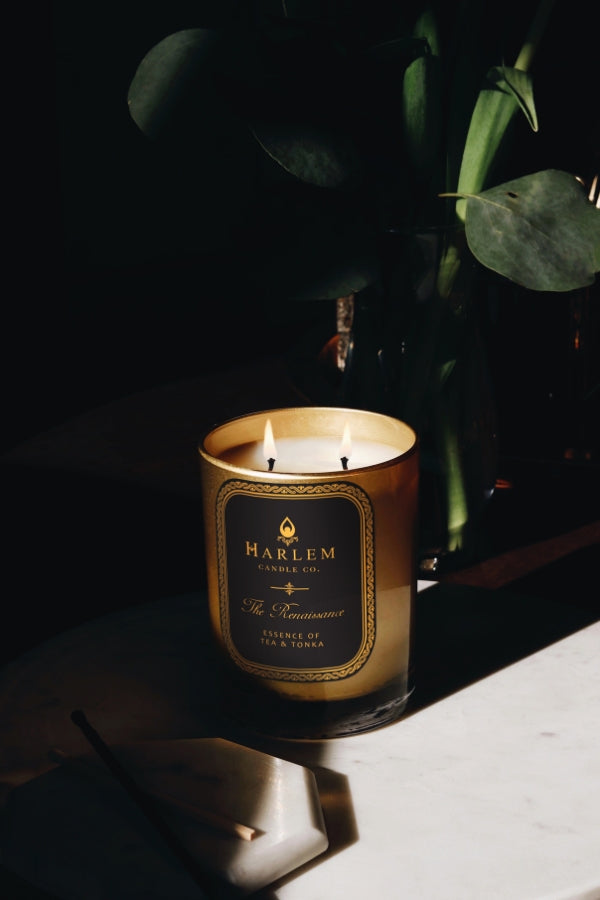 This is an image of our 2 wick Renaissance candle in a lifestyle setting with greenery in the background.
