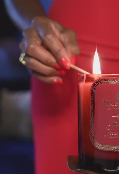 Woman in red dress lighting the red Josephine candle