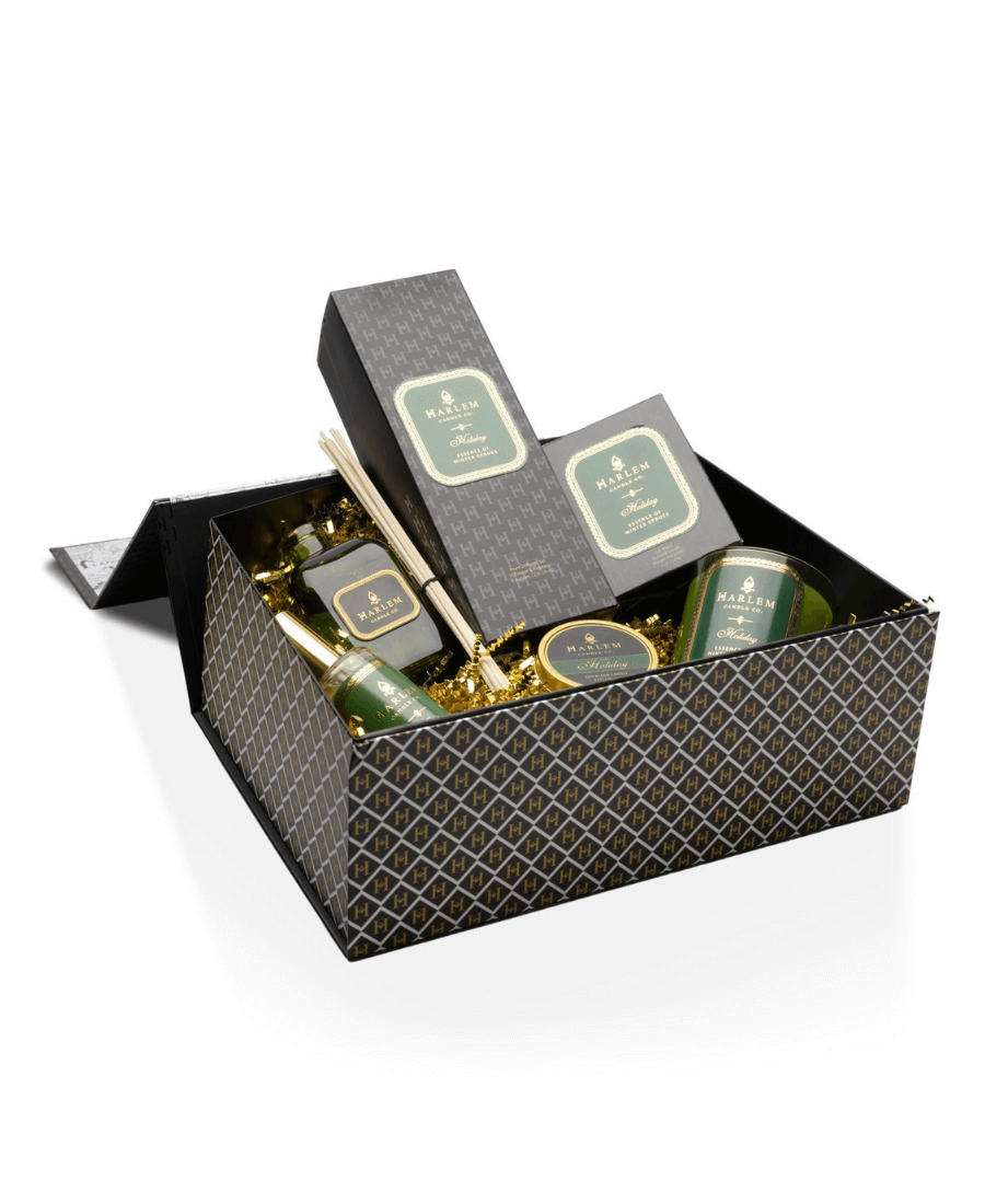 Our gorgeous custom Harlem Candle Co black gift box with the H pattern with the following items arranged inside the box with gold crinkle. Our Holiday 11 oz 1 wick candle, our 4 oz Holiday Travel Tin, our 4 fl oz Holiday Room spray and our green glass Holiday Reed Diffuser 