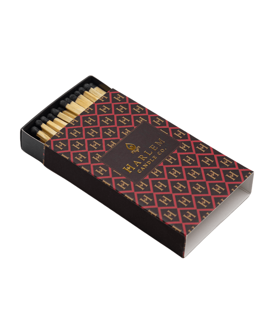 Red, black and gold match box containing 3 inch matches with black tips.  The box has the Harlem H pattern in an art deco style printed on the box.