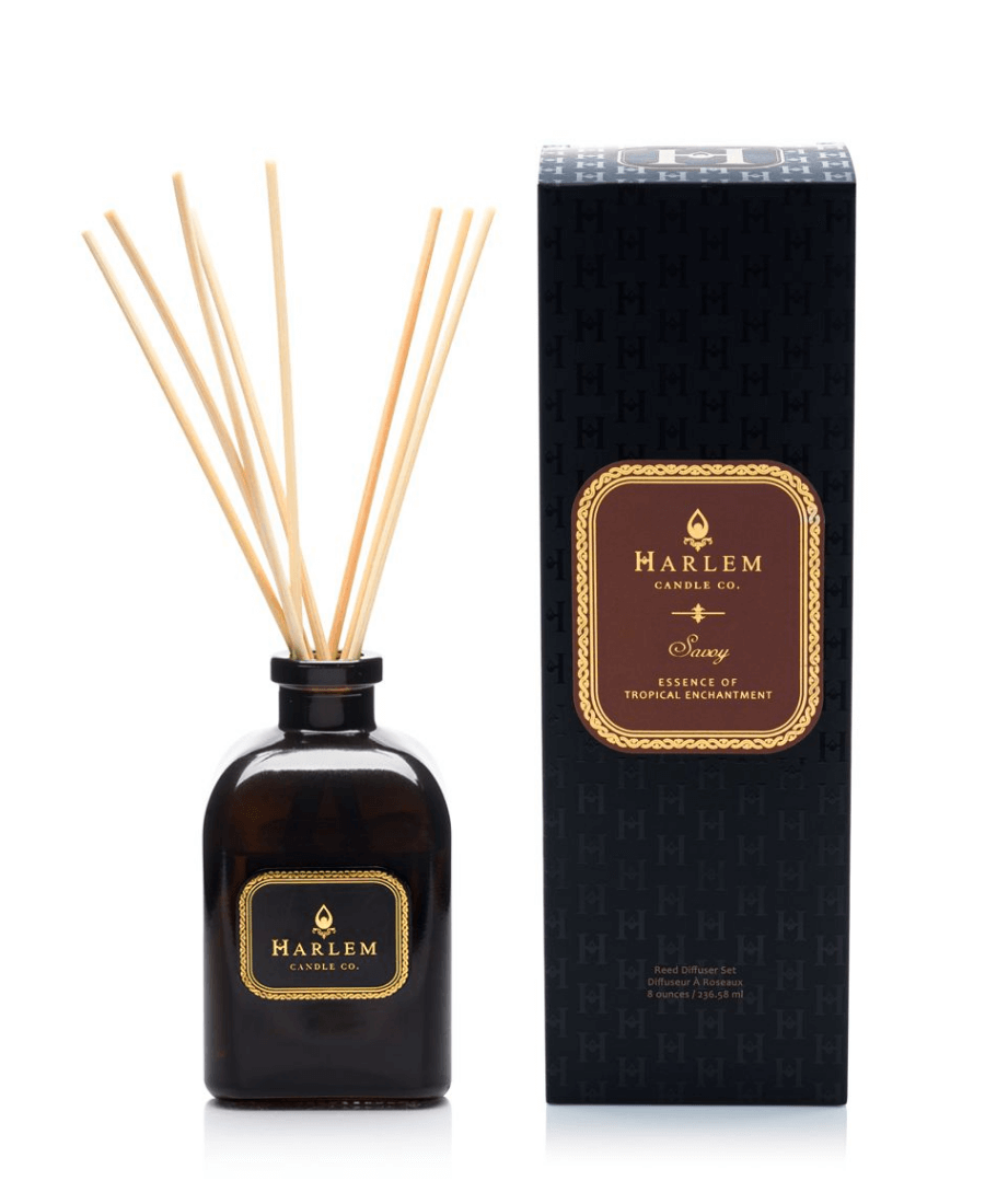 Our 4 fl oz Savoy Reed Diffuser with reeds in amber colored glass sitting next to its decorative box on a white background.