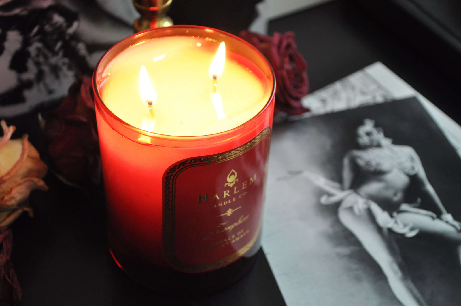 This is an image of our Josephine candle, illuminated next to a black-and-white picture of Josephine Baker