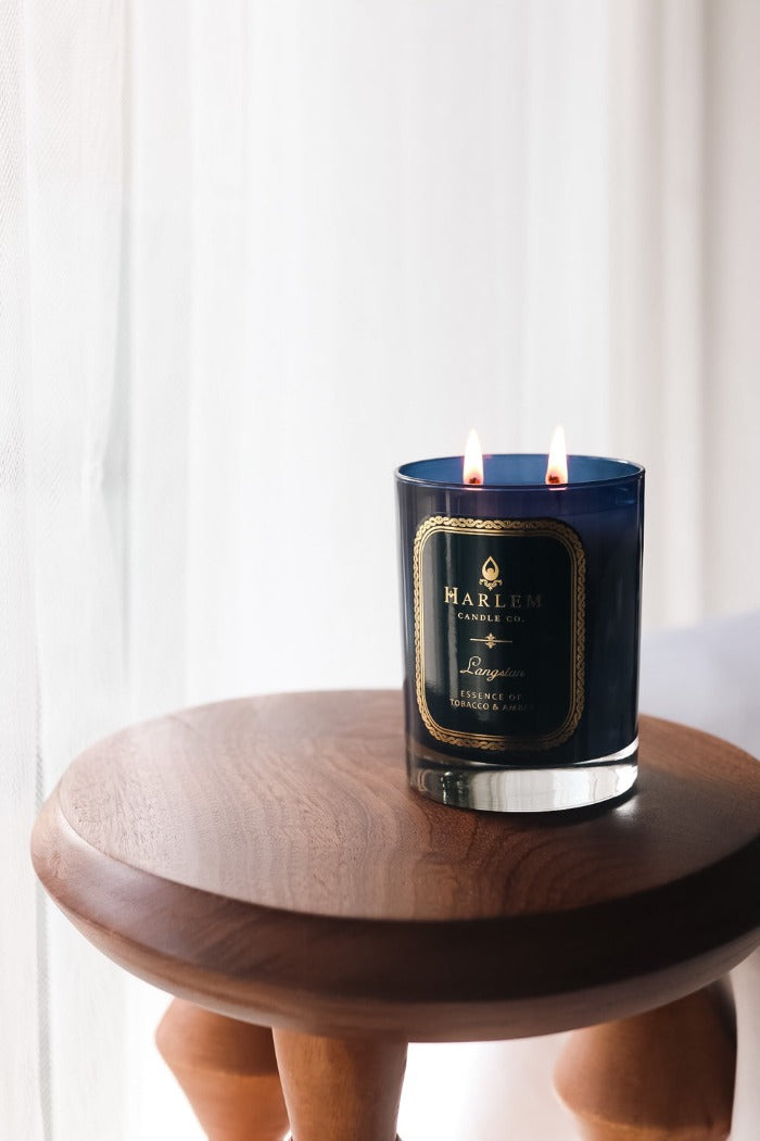 Our 11oz Langston Candle sitting on a wooden table. 