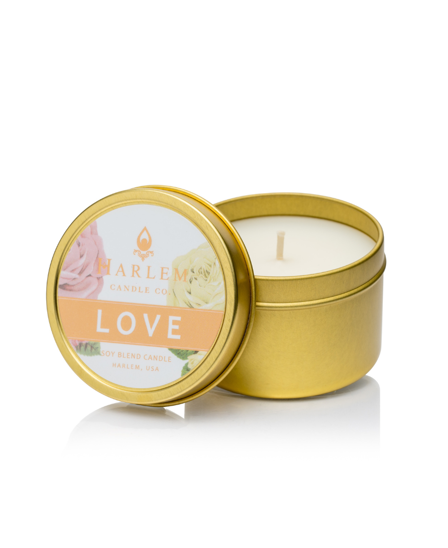 Our Love travel candle with one wick displayed in our gold metal tin.