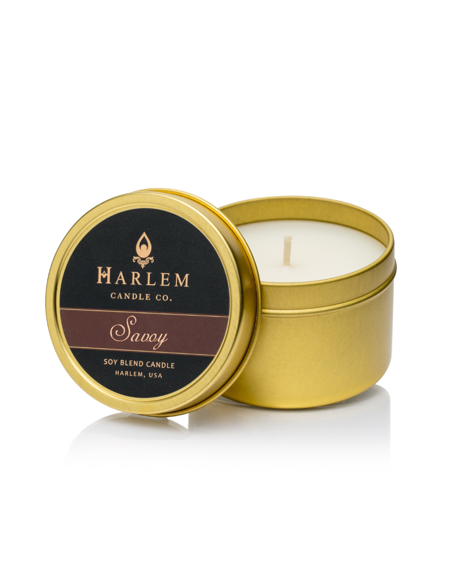 This is an image of our Savoy travel candle housed in bronze tin.  It has a gold lid with a black and brown label.