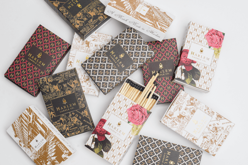 An array of all of our white, black, floral, red and goldpatterned match boxes and matches placed decoratively on a white background.