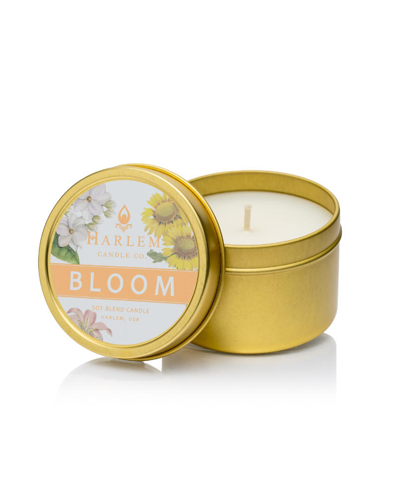 This is an image of our bloom, travel candle, and a bronze tin with the word bloom, and the Harlem Candle Company logo on the lid of the tin